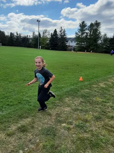 This photo features a child running on a field