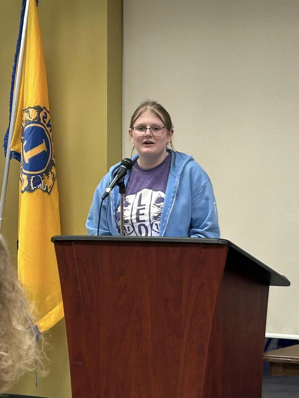 This photo features Abigail G. speaking behind a podium. 